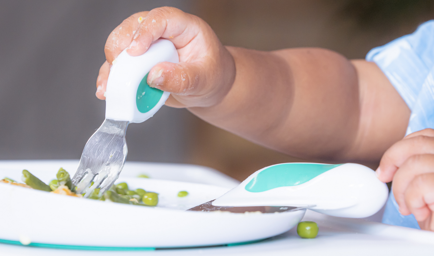 Toddler's food intake - little hand holding a doddl fork|Baby with blue spoon eating from a bowl|